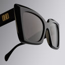 An image of the Cutler and Gross Akira 001 Cat Eye Sunglasses in Black frame detail close up from right side view with gold logo in temples.