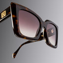 Tortoiseshell sunglasses with gradient lenses on a gray background