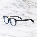 An image of the GR16 Round Opticals in Classic Navy Blue frame side view with arms open marble background