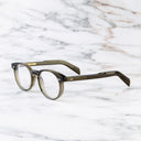 An image of the GR16 Round Opticals in Olive frame side view with arms open marble background