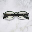 An image of the GR13 Oval Opticals in Striped Dark Green frame frontal view with arms closed marble background