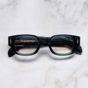 An image of the The Great Frog Soaring Eagle Square Optical Glasses in Deep Blue frame frontal view with arms closed marble background