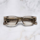 An image of the The Great Frog Soaring Eagle Square Optical Glasses in Sand Crystal frame frontal view with arms closed marble background