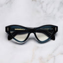 An image of the The Great Frog Mini Cat Eye Optical Glasses in Deep Teal frame frontal view with arms closed marble background