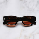 An image of the The Great Frog Soaring Eagle Rectangle Sunglasses in Havana frame frontal view with arms closed marble background