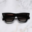 An image of the The Great Frog Love And Death Cat Eye Sunglasses in Black frame frontal view with arms closed marble background
