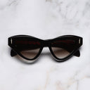 An image of the The Great Frog Mini Cat Eye Sunglasses in Black frame frontal view with arms closed marble background