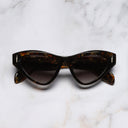 An image of the The Great Frog Mini Cat Eye Sunglasses in Brush Stroke frame frontal view with arms closed marble background
