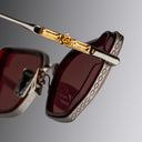 An image of the Cutler and Gross The Great Frog Paisley Cat Eye Sunglasses in Gun Metal/Bordeaux frame detail close up of right hinge and temple.