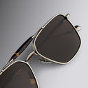 An image of the Cutler and Gross The Great Frog Capri Rectangular Sunglasses in Silver/Havana frame detail close up of left lens and right temple.