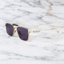 An image of the Cutler and Gross The Great Frog Capri Rectangular Sunglasses in Gold/Dark Grey frame side view with arms open marble background.