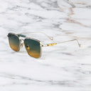 An image of the Cutler and Gross The Great Frog Capri Rectangular Sunglasses in Silver/Green frame side view with arms open marble background.
