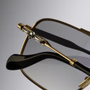 An image of the Cutler and Gross The Great Frog Ganton Navigator Sunglasses in Gold/Silver frame detail close up of left lens and temple