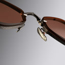 An image of the Cutler and Gross The Great Frog Carol Rectangular Sunglasses frame detail close up from front-center view