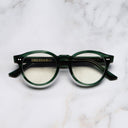 An image of the 1378 Blue Light Filter Optical Round Glasses (Small) in Striped Dark Green frame frontal view with arms closed marble background