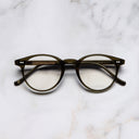 An image of the 0710 Kingsman Optical Round Glasses in Olive frame frontal view with arms closed marble background