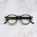 An image of the 1313 Kingsman Optical Round Glasses in Black frame frontal view with arms closed marble background