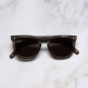 An image of the 0824 Kingsman Round Sunglasses in Smoke Italian frame frontal view with arms closed marble background