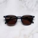 An image of the 1007 Kingsman Round Sunglasses in Marine Blue frame frontal view with arms closed marble background