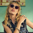 An image of Staz Lindes wearing the Cutler and Gross The Great Frog Paisley Cat Eye Sunglasses in Gun Metal/Bordeaux frame.