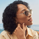 Side image of female model wearing the 
Breitling Léman 0001 Square Sunglasses in Dark Grey, looking to the left.