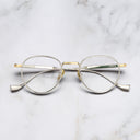 An image of the Lennox 1428 Round Opticals in Silver/Gold frame frontal view with arms closed marble background