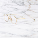 An image of the Lennox 1428 Round Opticals in Gold frame side view with arms open marble background