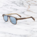 An image of the GR14 Aviator Sunglasses in Grey on Granny Chic frame side view with arms open marble background