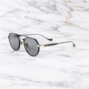 An image of the Draycott 1426 Round Sunglasses in Black/Gold frame side view with arms open marble background