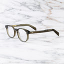 An image of the GR16 Round Opticals in Olive frame side view with arms open marble background
