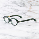 An image of the GR13 Oval Opticals in Striped Dark Green frame side view with arms open marble background