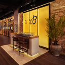 Image of inside a Breitling store, with a yellow background and watch bar. 