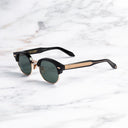 An image of the Breitling Biarritz 0003 Round Sunglasses in 18K Red Gold frame side view with arms open marble background