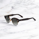 An image of the Breitling Biarritz 0003 Round Sunglasses in Classic Havana frame side view with arms open marble background