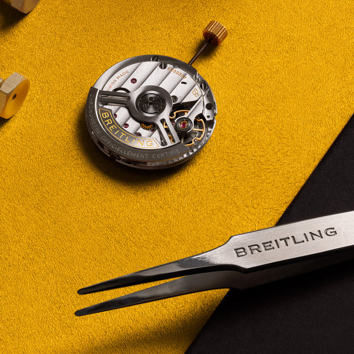 Watch mechanism and Breitling tools on a yellow background