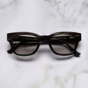 An image of the Cutler and Gross 0772 Square Horn Sunglass in Slate Grey Buffalo Horn frame frontal view with arms closed marble background