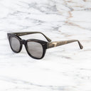 An image of the Cutler and Gross 0772 Square Horn Sunglass in Slate Grey Buffalo Horn frame side view with arms open marble background