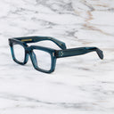 An image of the 9386 Square Optical in Deep Teal frame side view with arms open marble background