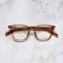An image of the GR05 Cat Eye Optical Glasses in Crystal Peach frame frontal view with arms closed marble background 