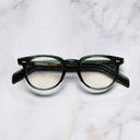 An image of the GR09 Round Optical Glasses in Striped Dark Green frame frontal view with arms closed marble background