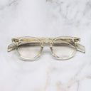 An image of the GR09 Round Optical Glasses in Butter Crystal frame frontal view with arms closed marble background 