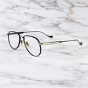 An image of the Pembroke 1429 Aviator Opticals in Black/Gold frame side view with arms open marble background