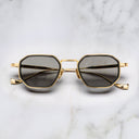 An image of the Cutler and Gross Carlyle 1437 in Gold/Black frame frontal view with arms closed marble background.