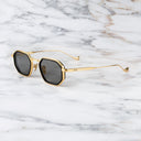 An image of the Cutler and Gross Carlyle 1437 in Gold/Black frame side view with arms open marble background.