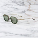 An image of the Cutler and Gross Carlyle 1437 in Antique Silver/Green frame side view with arms open in marble background.