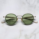 An image of the Cutler and Gross Brompton 1438 in Antique Green/Silver  frame frontal view with arms closed in marble background.