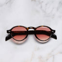 An image of the GR08 Round Sunglasses in Havana frame frontal view with arms closed marble background 