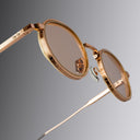 An image of the Cutler and Gross Brompton 1438 in Pink Gold/White Horn  frame detail close up from right side view with arms open in grey background.