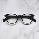 An image of the GR16 Round Opticals in Classic Navy Blue frame frontal view with arms closed marble background