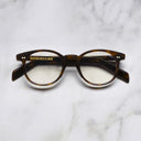 An image of the GR16 Round Opticals in Havana frame frontal view with arms closed marble background